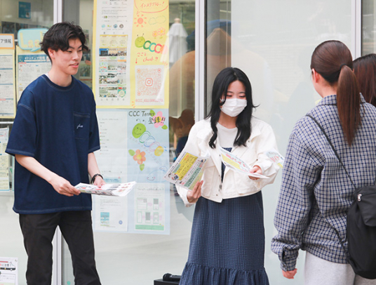 闇バイトへの注意を呼びかけ、チラシを配る学生ら=長久手市の愛知淑徳大で