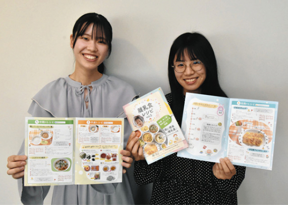 制作に携わったレシピ冊子を手にする山田さん(左)と神谷さん=千種区の椙山女学園大で