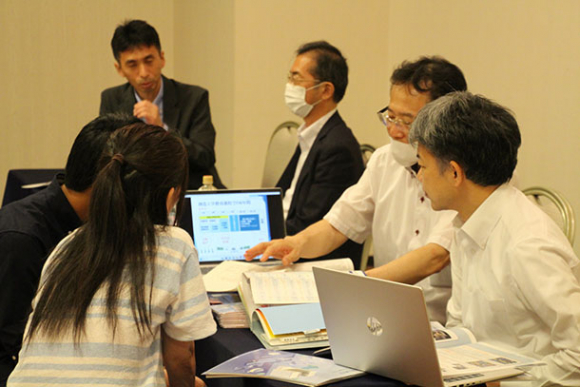 大学の担当者（右側）から入試や学生生活などの説明を受ける来場者＝金沢市堀川新町で