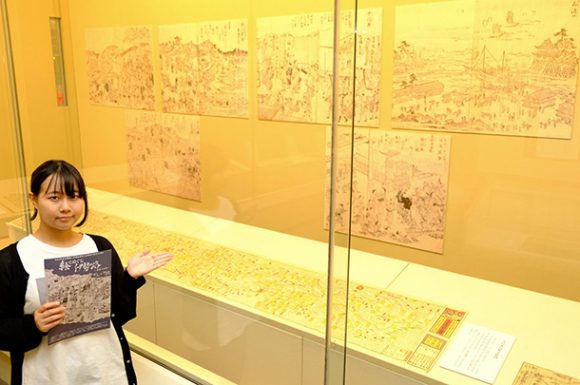 「絵でめぐる伊勢路」の展示を紹介する奥野さん=伊勢市の皇学館大佐川記念神道博物館で
