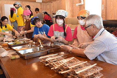 住民と一緒におはぎを作って交流する学生たち＝石川県能登町で