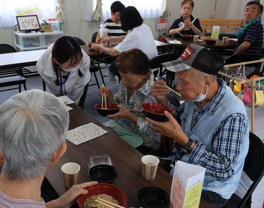 学生らと懇談しながら、そうめんを味わう仮設住宅の住民ら＝石川県穴水町大町で