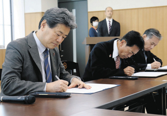 協定書に署名する（左から）原田学長、田島市長、磯谷会長＝彦根市役所で