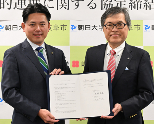 協定書を手にする大友学長（右）と柴橋市長＝岐阜市役所で