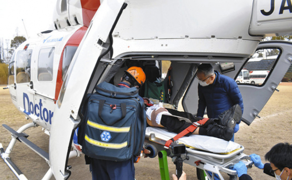 負傷者役をドクターヘリに運び込む隊員ら＝緑区鳴海町で