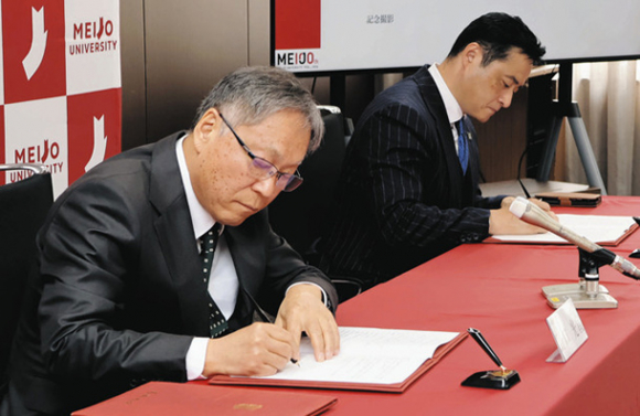 産学連携協定にサインする（左から）野口学長と井崎バイスプレジデント＝名古屋市天白区の名城大天白キャンパスで