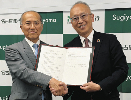 協定書を手に握手する椙山女学園大の黒田学長（左）と名古屋銀の藤原頭取＝千種区の椙山女学園大で