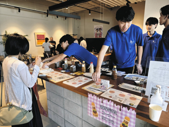 昨年８月、地域住民向けの試食会でドレッシングの出来栄えを調査する学生たち＝名古屋市千種区で