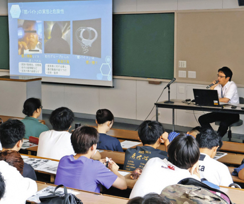 光家警部補（右奥）の話を聞く学生たち＝瀬戸市の名古屋学院大瀬戸キャンパスで