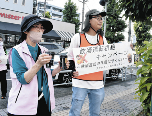啓発品のコーヒーを手に飲酒運転根絶を呼びかける参加者=天白区の平針駅前で
