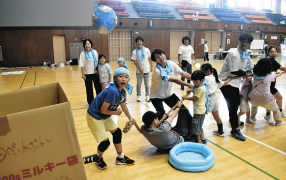 独自ルールの綱引きで、最後尾から箱にボールを投げ込む参加者＝日進市の愛知学院大で
