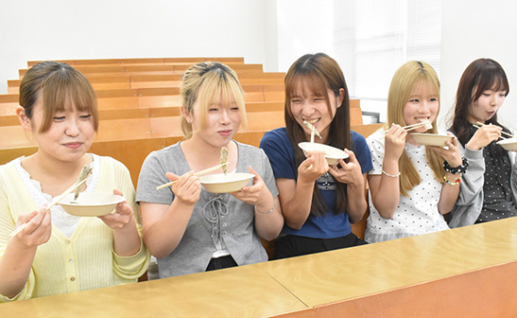 メヒカリの唐揚げなどを試食する学生たち=日進市の名古屋学芸大で