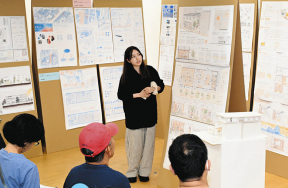 近隣住民らに図面や模型を用いて設計を発表する後藤さん（中央）＝港区名港１の港まちポットラックビルで