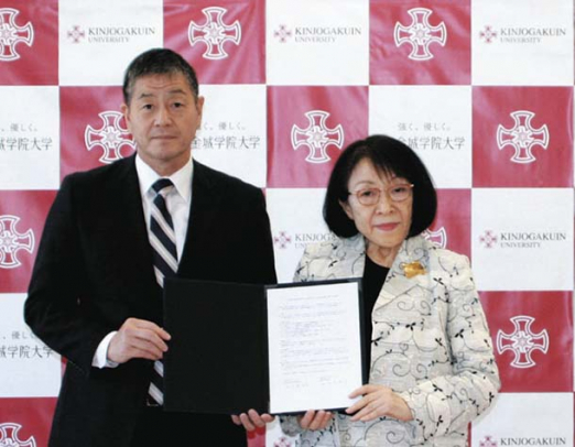 協定書にサインした小塚校長(左)と小室学長=名古屋市守山区の金城学院大で