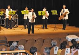 還暦式で、愛知東邦大生の演奏を聞く参加者ら＝名東区上社１の名東文化小劇場で