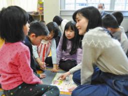 クイズ冊子を使って学生（右）と答えを考える児童ら＝千種区の内山小で