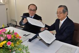 署名し協定書を交わす豊田学長（左）と新田校長＝鈴鹿市の鈴鹿高専で