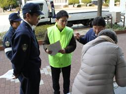 銀行の来店者にチラシを配る学生（中）＝東区徳川で