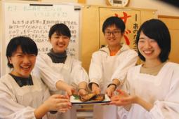 試作したサバ煮を手にする学生たち＝岐阜県恵那市岩村町で