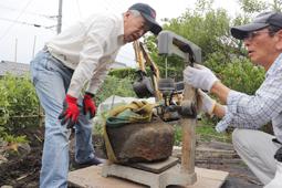 鉄滓と見られる物体の重さを量る住民たち＝長浜市国友町で