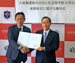 協定書を交わした末安理事長（右）と吉田支店長