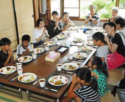 ボランティアの大学生らと食卓を囲む子どもたち＝蒲郡市三谷町の八剱神社社務所で