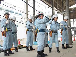 電線を覆うゴムの切り取り作業を体験する学生たち＝名古屋市南区滝春町１のトーエネック教育センターで