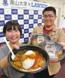 ローソンと共同開発した「２種のあいがけカレー」を手にする南山大の祝迫さん（左）ら＝昭和区の南山大で