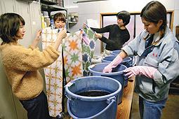 有松絞りまつりでの販売に向け、手拭いを染める学生ら＝名古屋市緑区有松のスズサンで