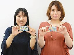 日進市にちなんだデザインのキャッシュカードを手にする名古屋学芸大の鷲島さん（左）と小川さん