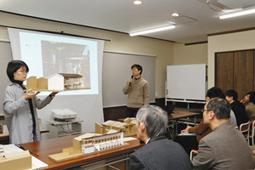 模型を見せながら発表する明治大大学院の院生＝小松市龍助町で