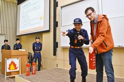 留学生に消火器の使い方を教える学生たち＝昭和区の南山大で