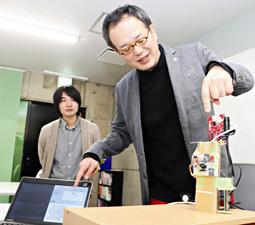 機械の説明をする金沢工業大の中沢実教授＝金沢市油車で