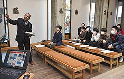 ムンシ准教授（左）の説明に耳を傾ける生徒たち＝昭和区の南山中男子部で