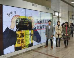 駅構内で流れる広告動画。右の３人は制作した大学生＝ＪＲ名古屋駅で