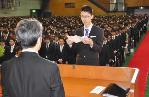 大沢敏学長（左）を前に答辞を述べる日向直之さん＝野々市市の金沢工業大で