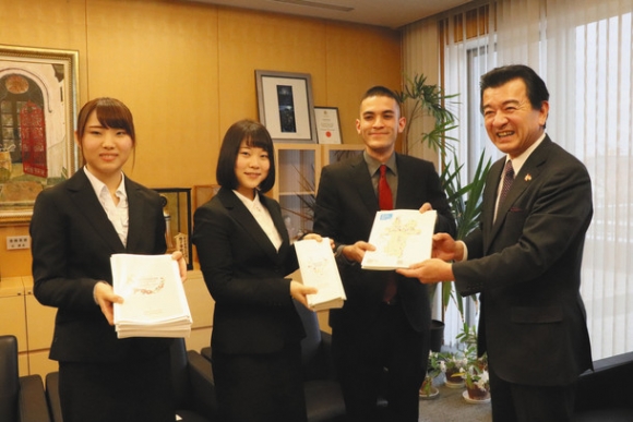 完成したパンフレットを粟貴章市長（右）に手渡す学生たち＝野々市市役所で