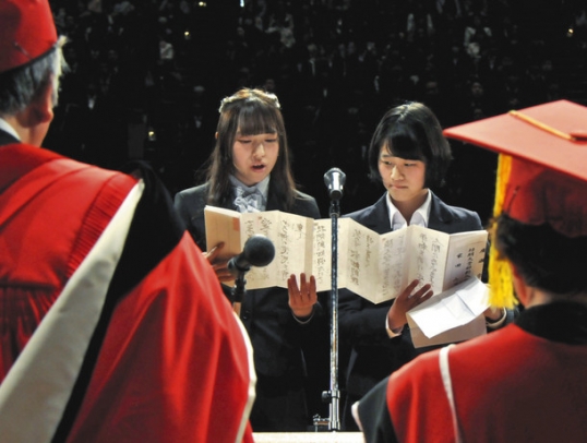 誓いの言葉を述べる家田さん（中央左）と広瀬さん（同右）＝関市文化会館で