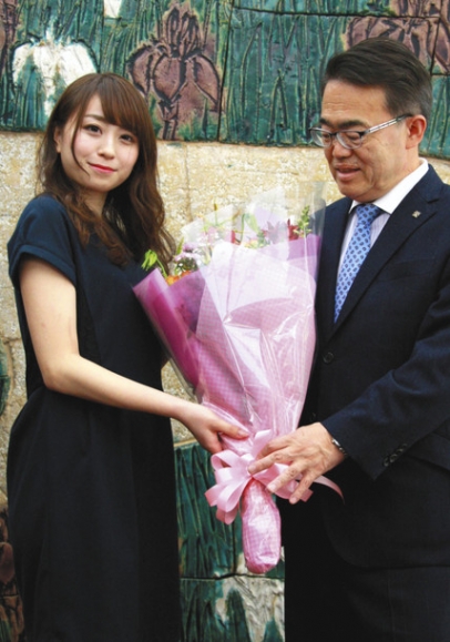 大村知事（右）から祝福の花束を受け取る中村さん＝県公館で
