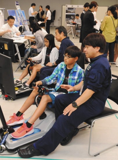 シミュレーターで航空機の操縦に挑戦する中学生（中央）＝豊山町のあいち航空ミュージアムで
