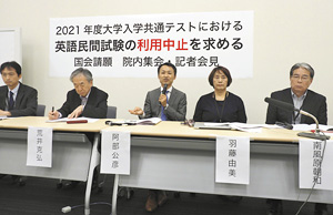 英語の民間検定試験の当面の利用中止を求めて記者会見する東大の阿部公彦教授(中央)ら=6月18日、国会で